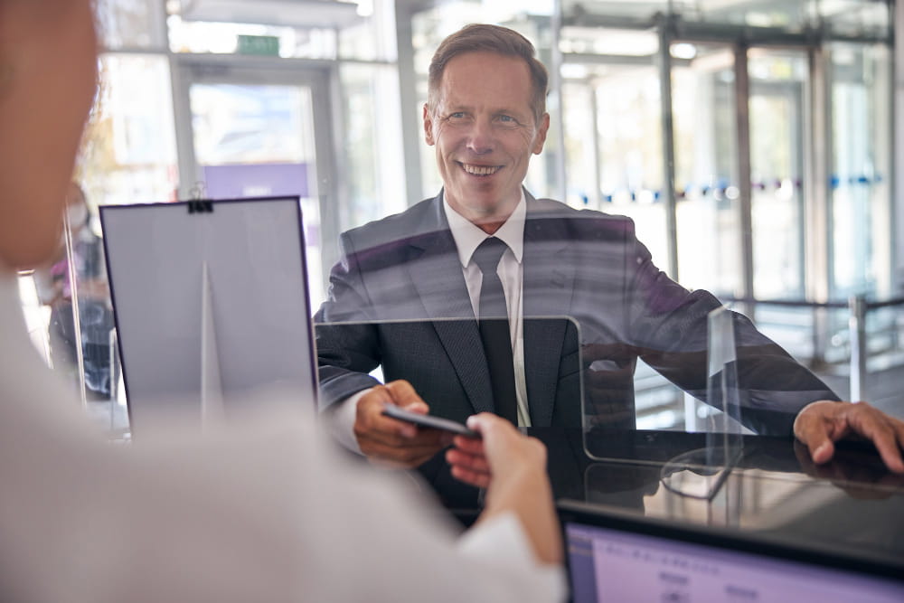 Un client échange avec un conseiller professionnel au guichet d'une banque d'affaires moderne