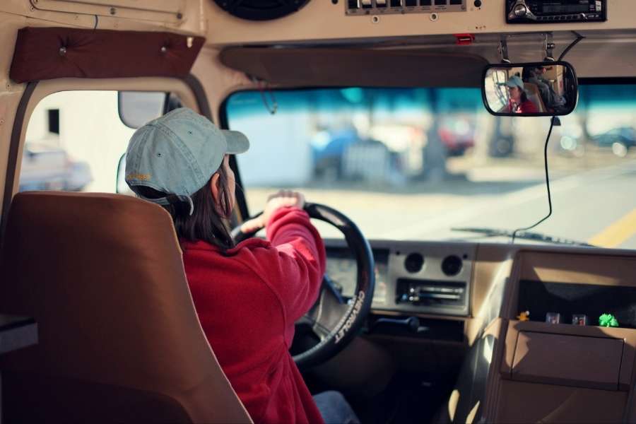 Une jeune conductrice est assise au volant de son véhicule pour l'apprentissage des jeunes conducteurs.